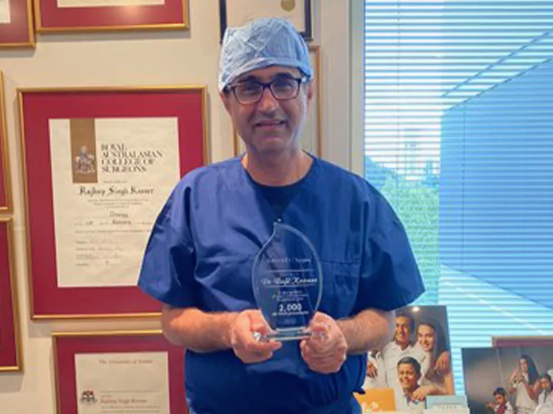 Dr Raji Kooner with a presentation trophy marking 2,000 robotic surgical cases