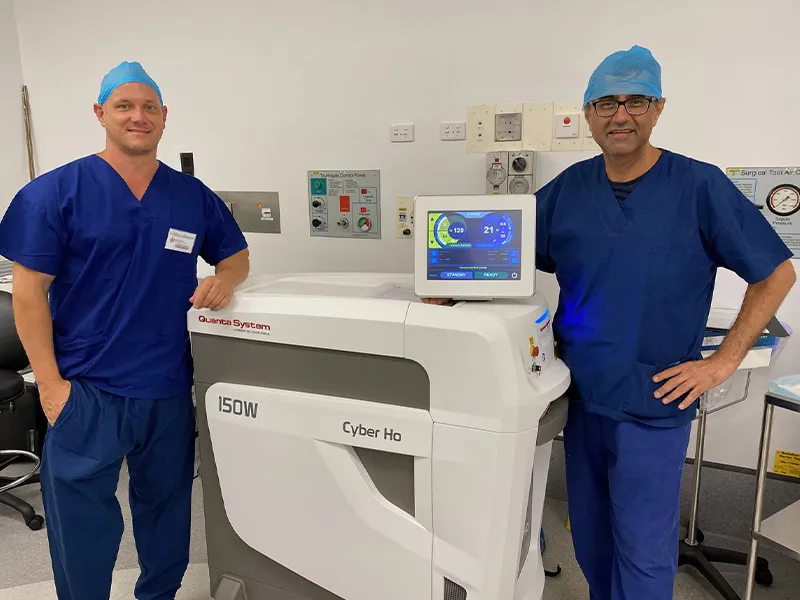 Dr Raji Kooner and a colleague beside a holmium laser platform in theatre