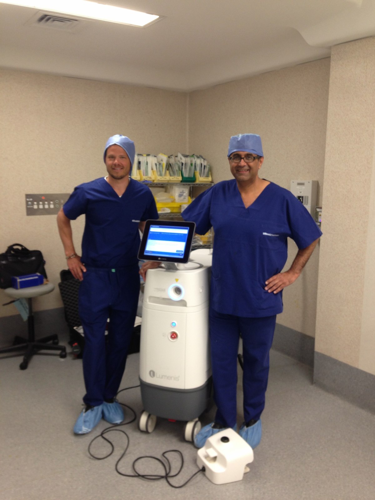Dr Raji Kooner with a colleague beside a Lumenis holmium laser platform in theatre