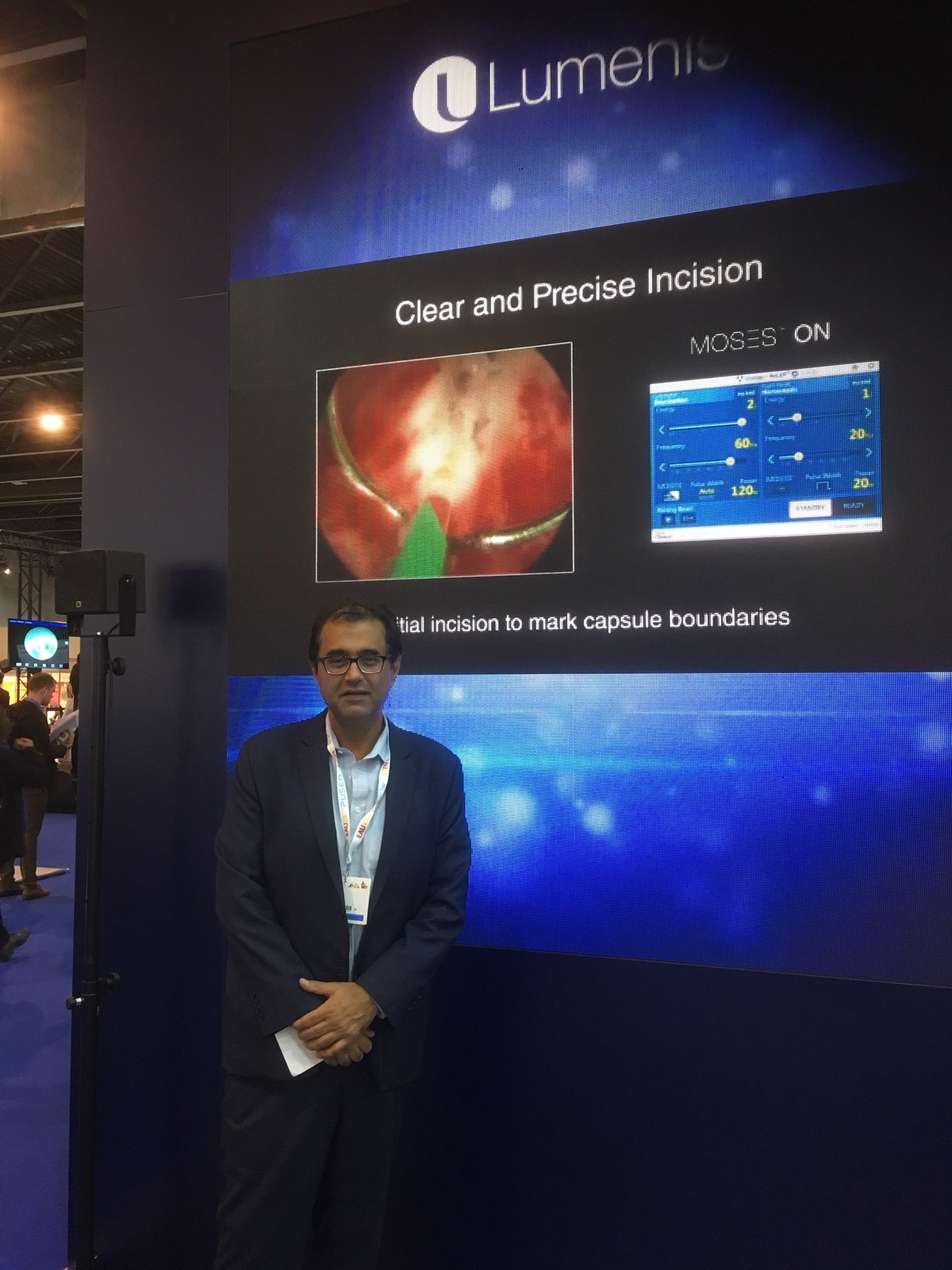 Dr Raji Kooner beside a Lumenis MOSES technology display at a conference