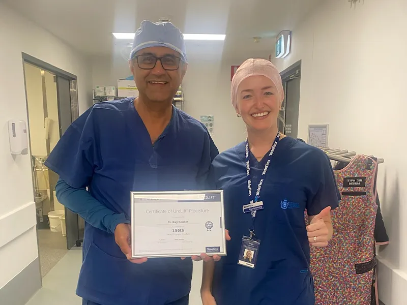 Dr Raji Kooner holding a certificate marking his 150th UroLift procedure