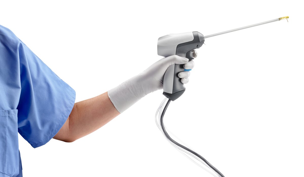 Gloved clinician holding the Rezūm handheld delivery device.